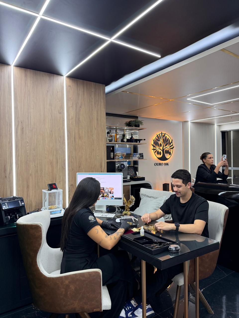 Atendente avaliando peças de ouro com o cliente